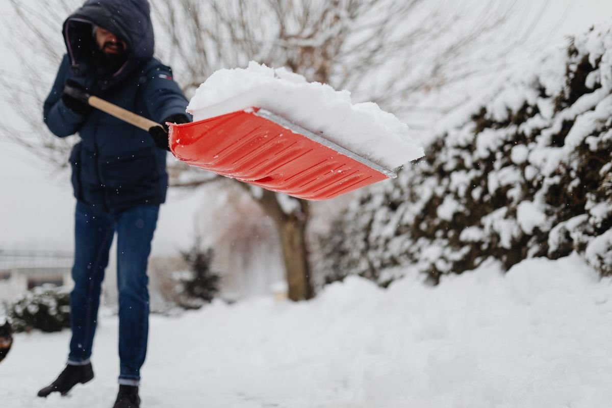 Professional crew member shoveling snow from residential properties for Snow Removed