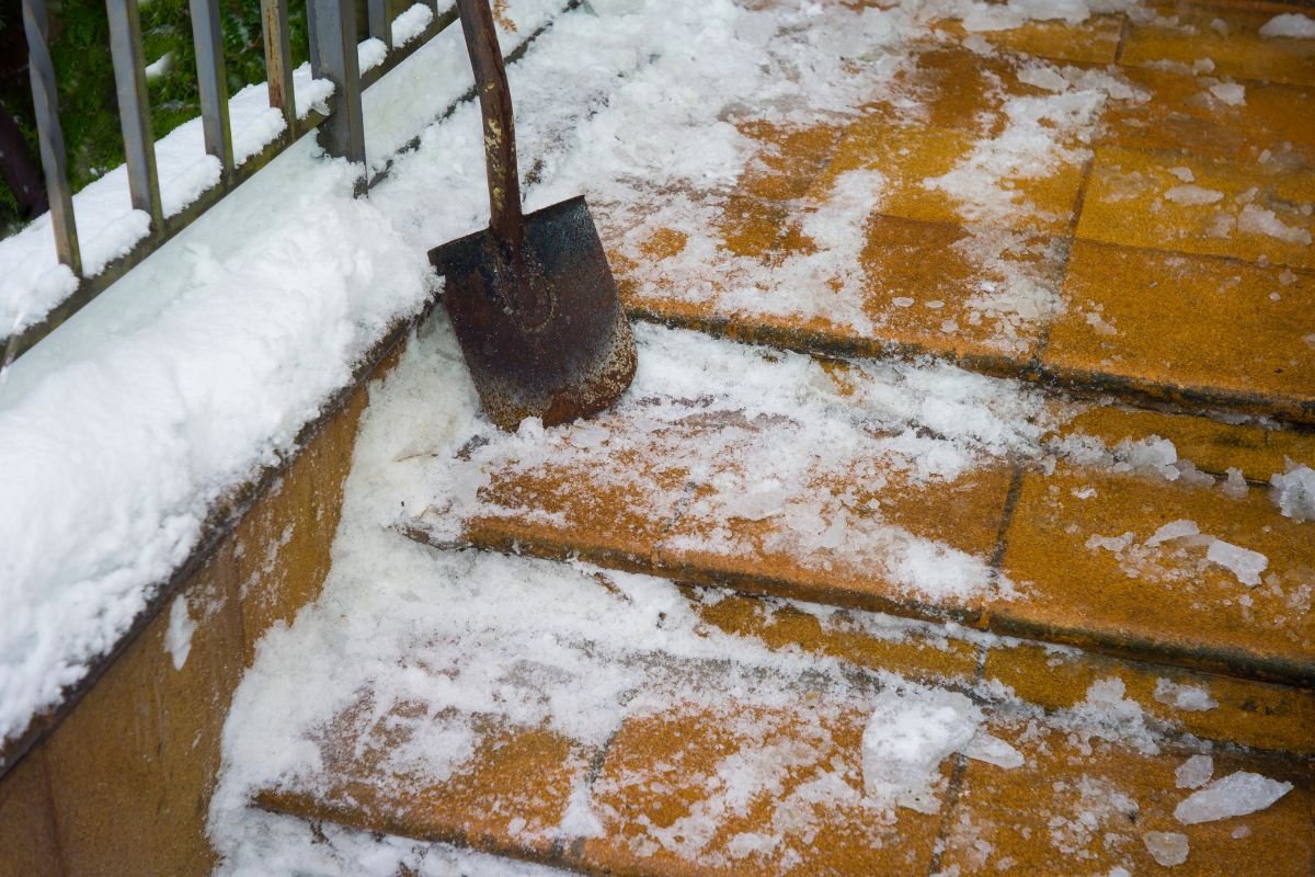 Manual snow and ice clearing on residential stone steps by Snow Removed