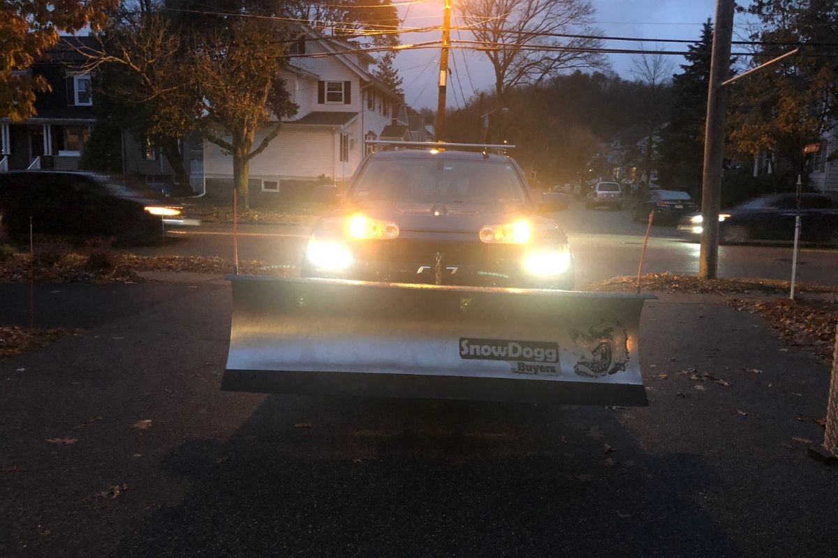 Professional snow plow truck operating on residential streets for Snow Removed in Massachusetts